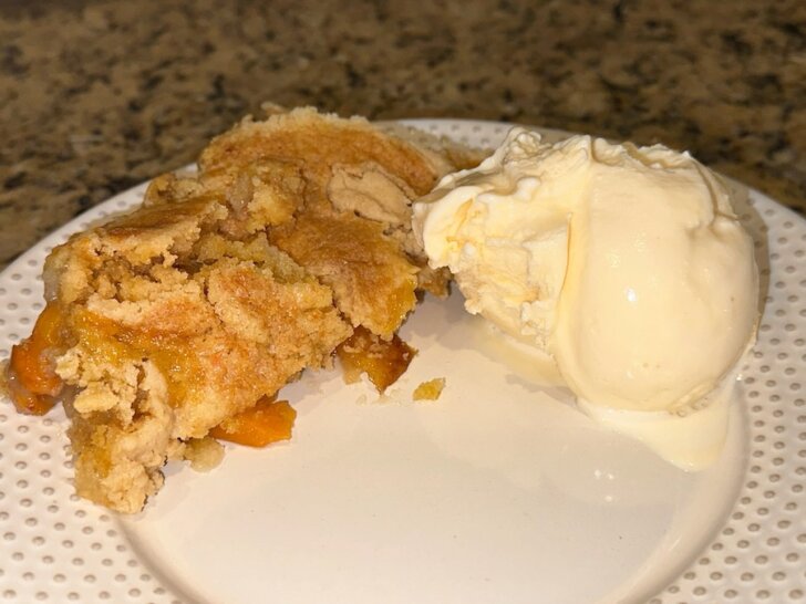 Peach dump-cake and vanilla ice cream on plate