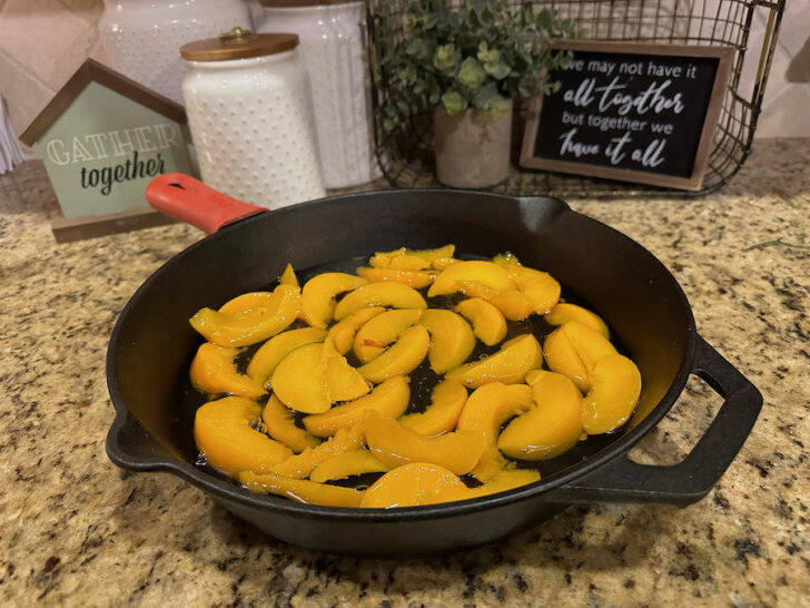 Canned peaches poured into cast-iron skillet