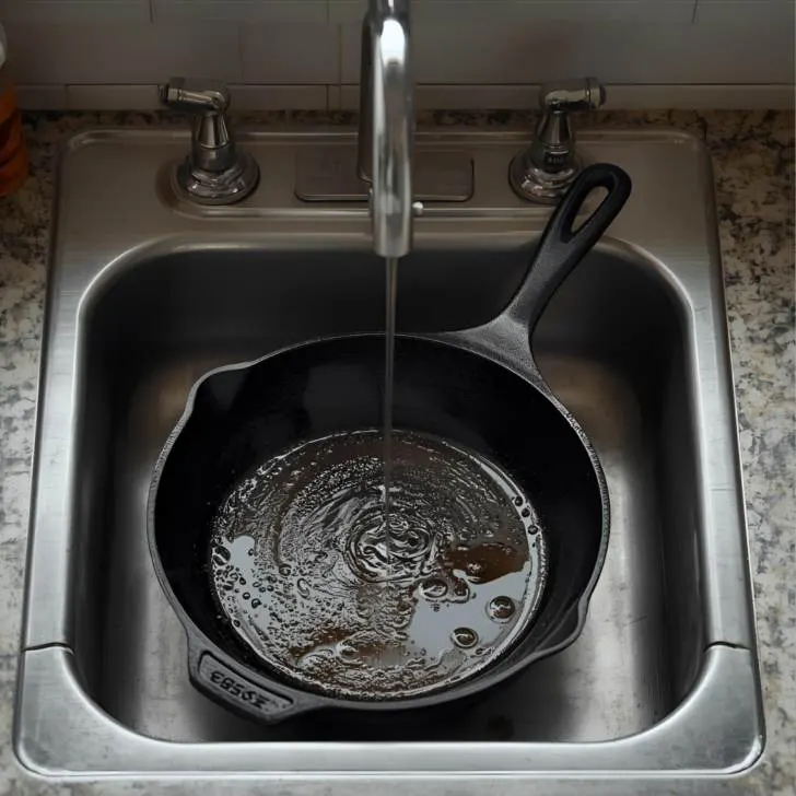 cast iron skillet in sink with water
