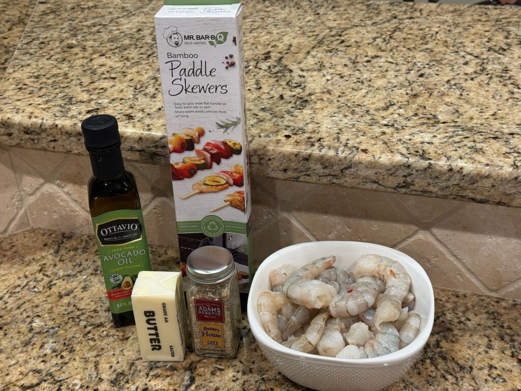 raw shrimp in bowl with seasonings on counter nearby