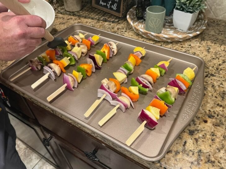 doctoring the veggie skewers before they go on the grill