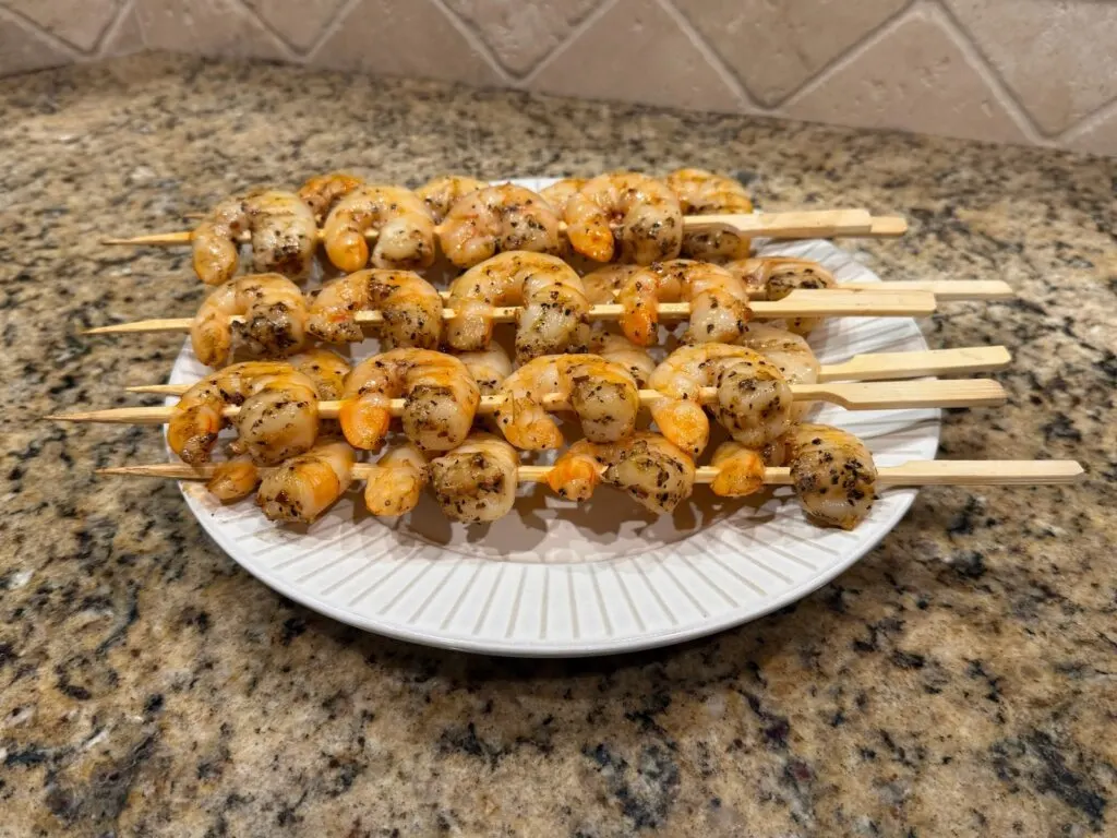 beautiful cooked skewered shrimp on plate, ready to serve