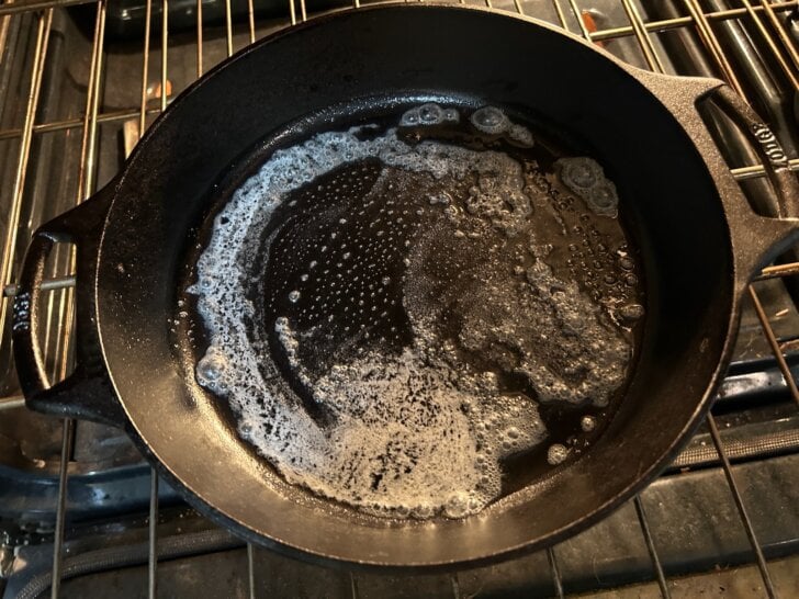 piping hot cast iron skillet in oven with butter on bottom, melted
