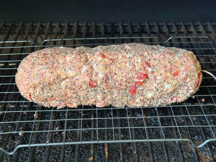 shaped meatloaf on rack in smoker with thermometr inserted