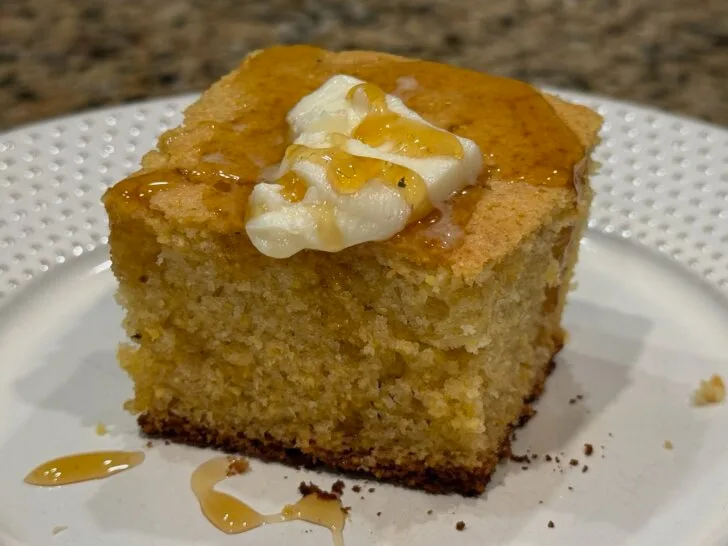 slice of cornbread with butter and honey on top