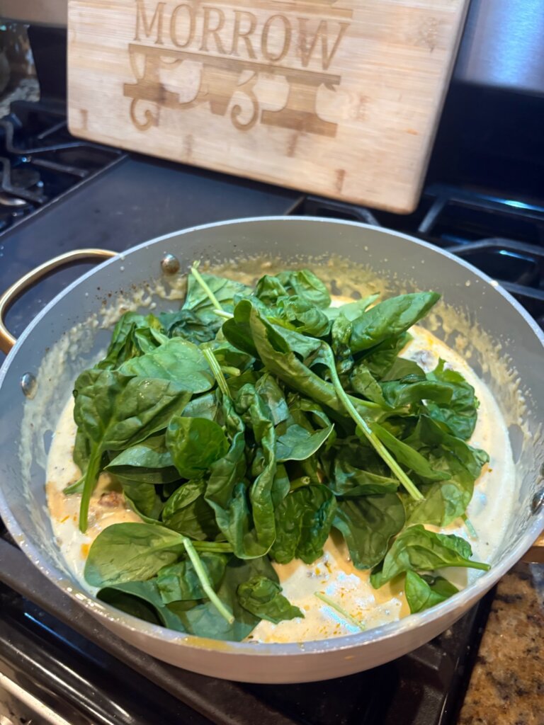 cheese sauce in pan with spinach