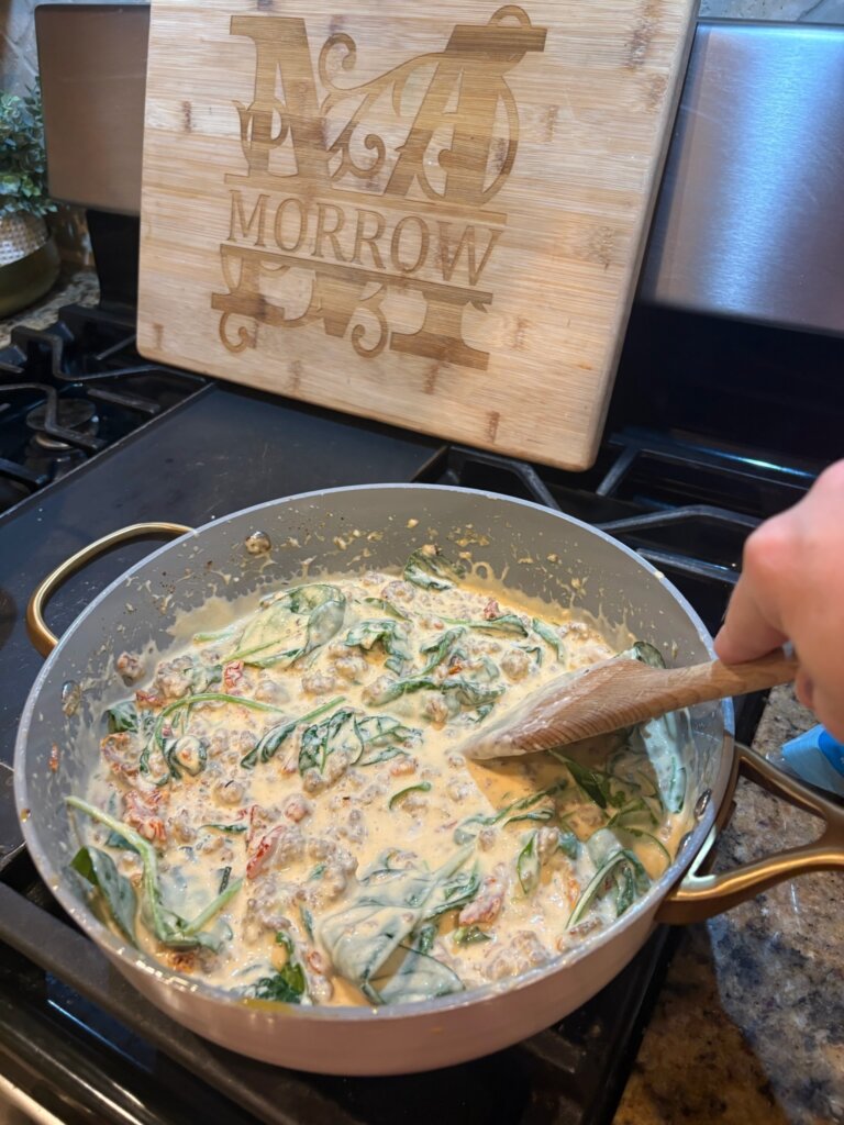 cheese sauce in pan with spinach, stirred