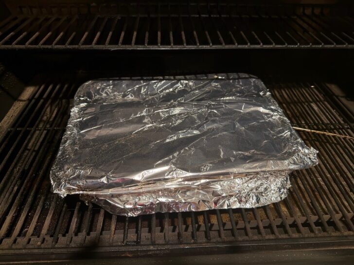 covered foil pan filled with Smoked Honey Bourbon Country-Style Ribs