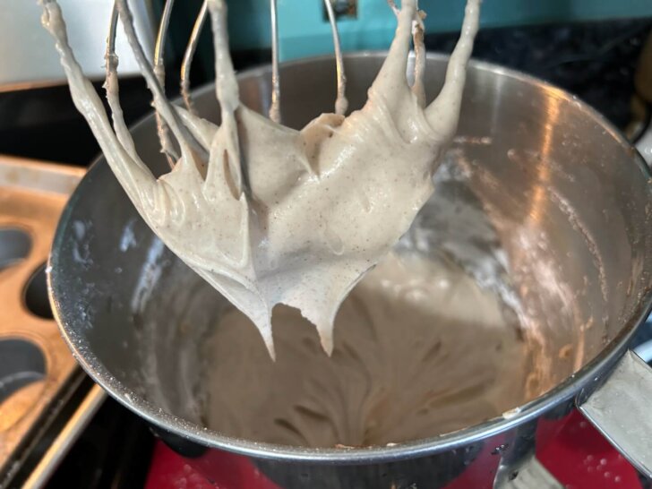 cinnamon cream cheese frosting in bowl and on mixer/beaters