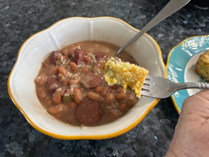 cornbread on fork, pinto beans and rice in bowl