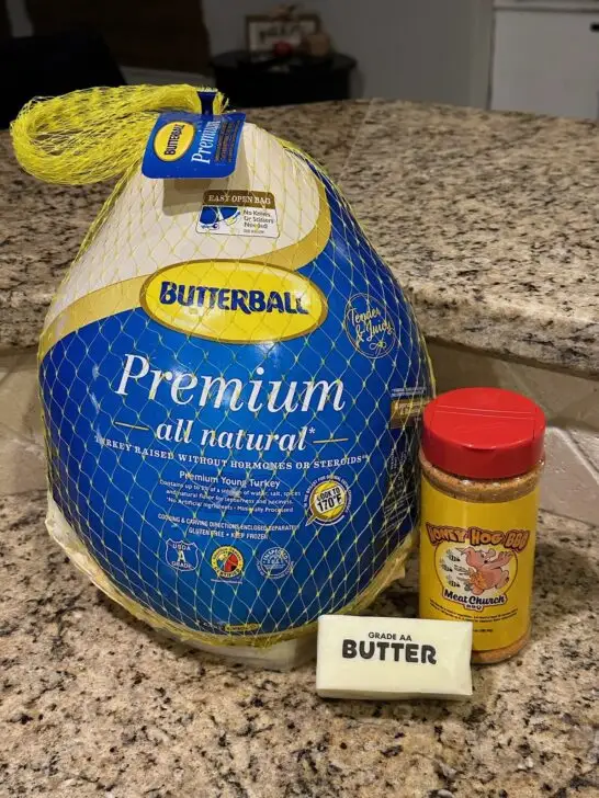 thawed turkey on countertop with seasonings and butter nearby