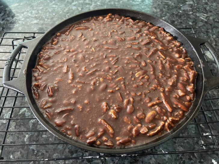 Texas sheet cake icing on top of brownies in skillet