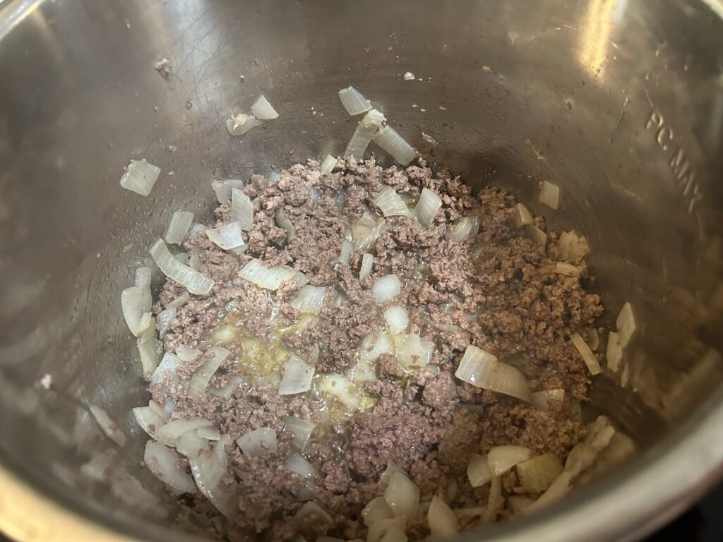 ground beef and onions sauteeing in pan