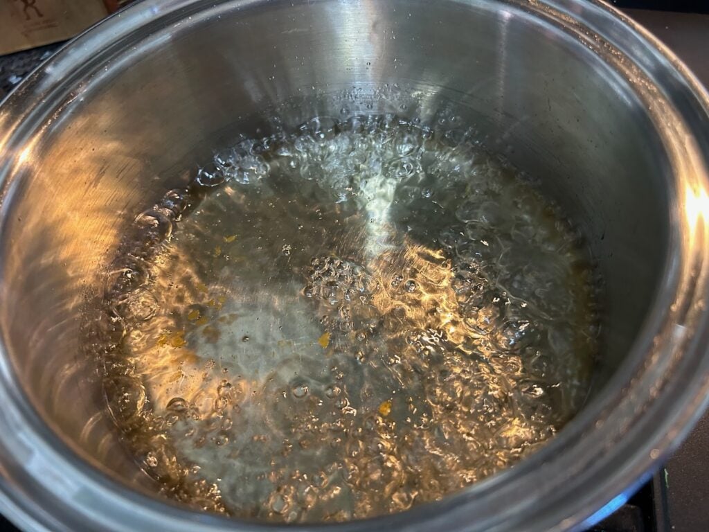 water and sugar syrup in pan on stove boiling