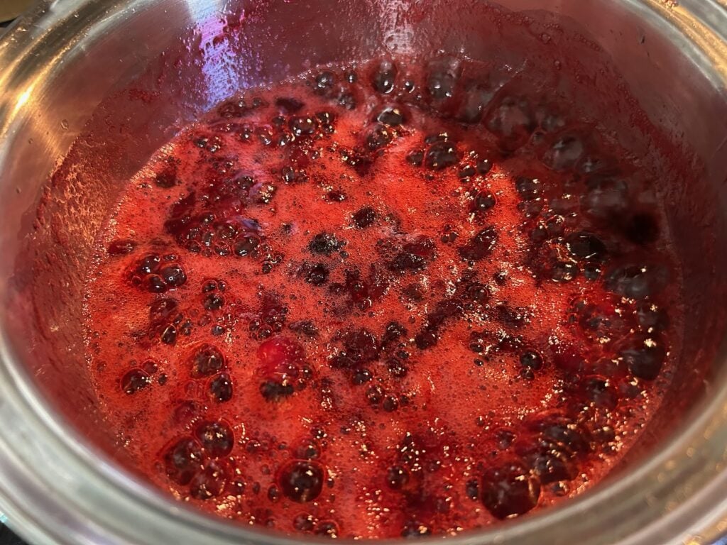 fresh cranberries simmering in pot on stove