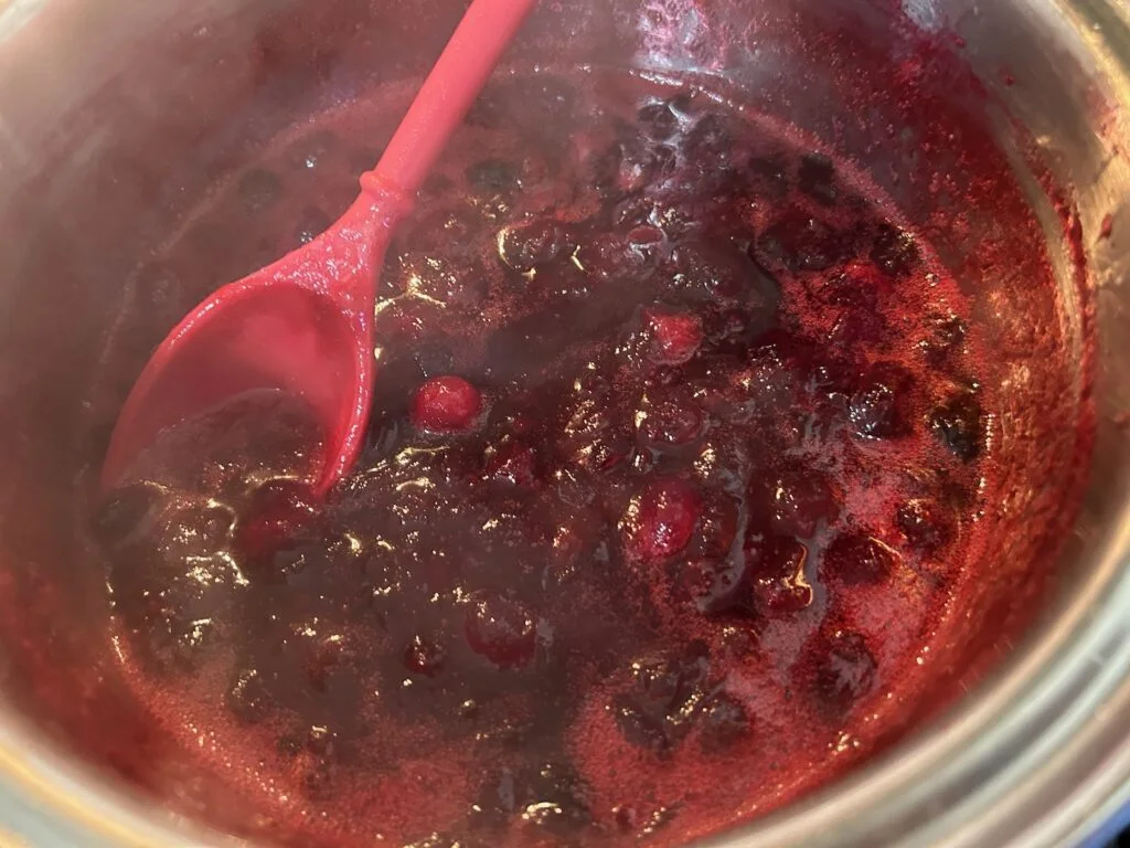 cranberries simmering in pot on stove