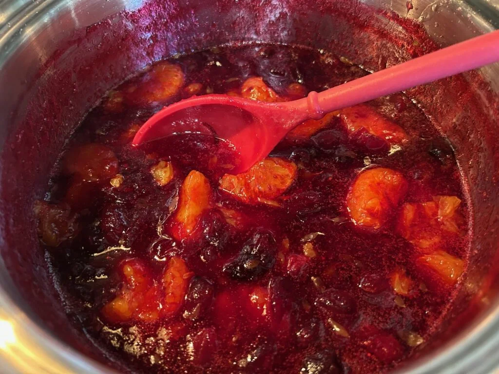 cranberries and mandarin oranges in pot on stove