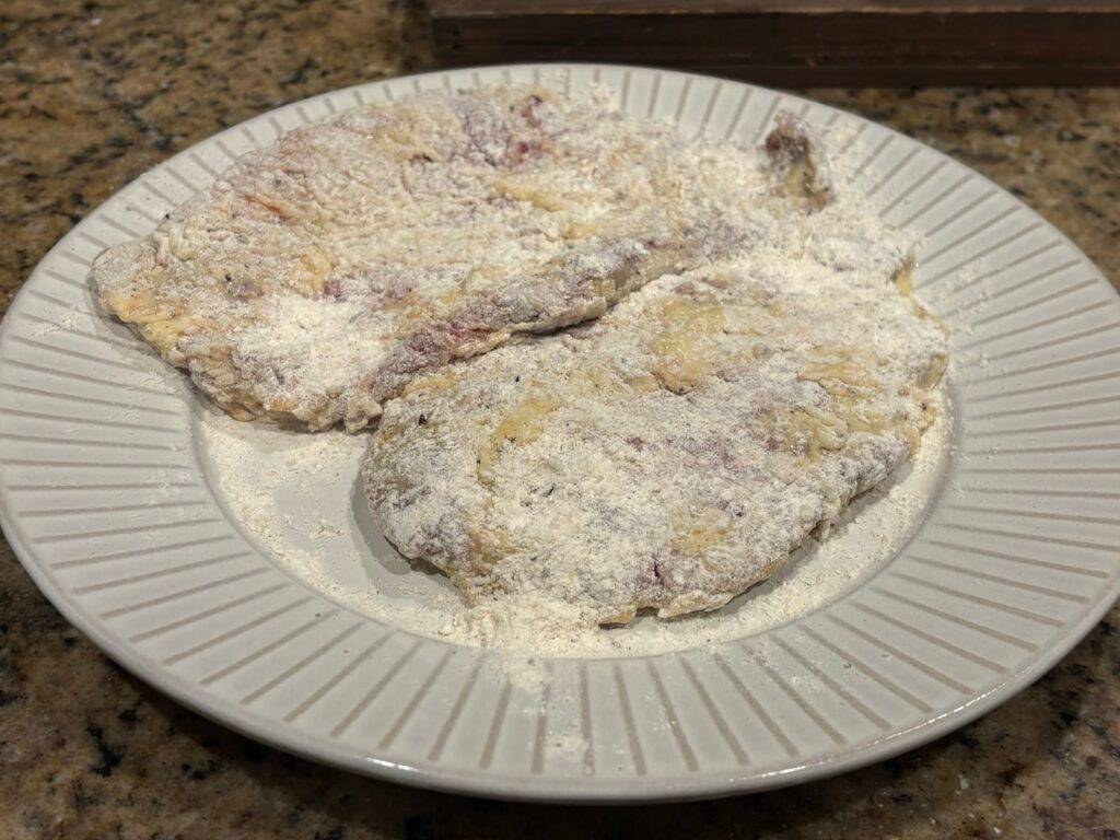 dredged and floured cutlets on plate, ready to cook