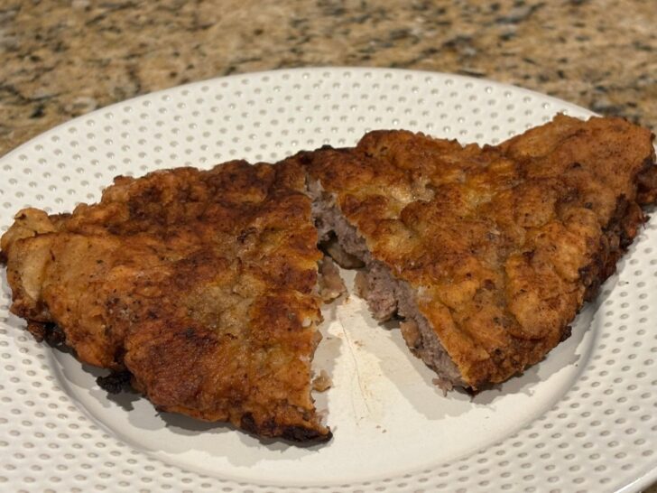 chicken fried steak on plate, cut open to show tender interior