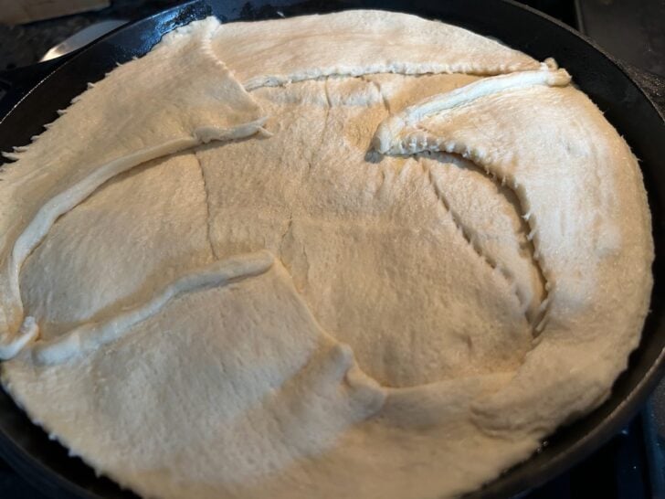 crescent roll topping on turkey pot pie in skillet