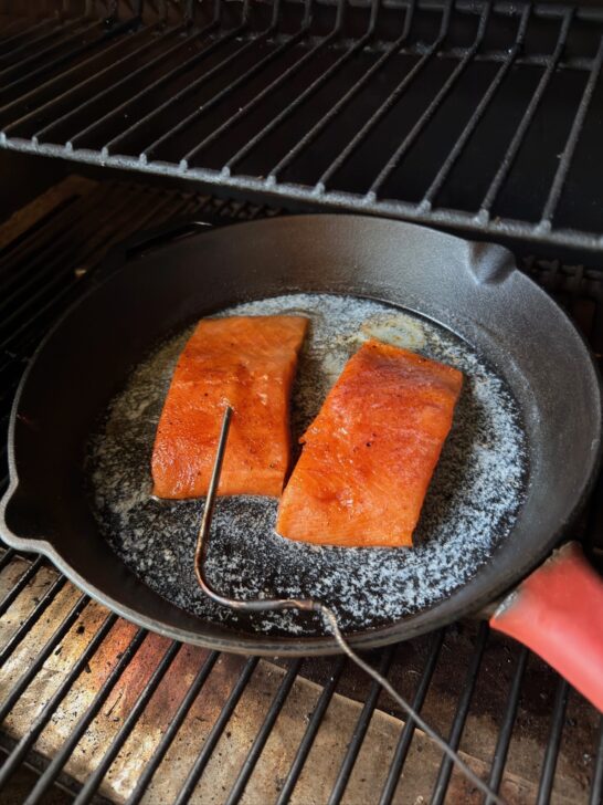salmon sizzling in cast iron skillet