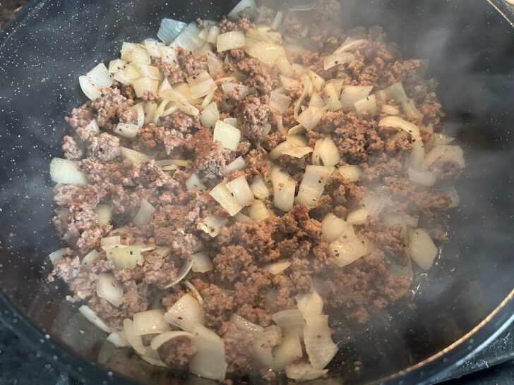beef and onions simmering in skillet