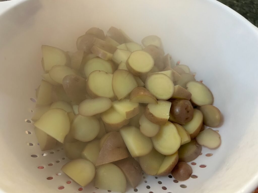 par-boiled potatoes cooling in colander