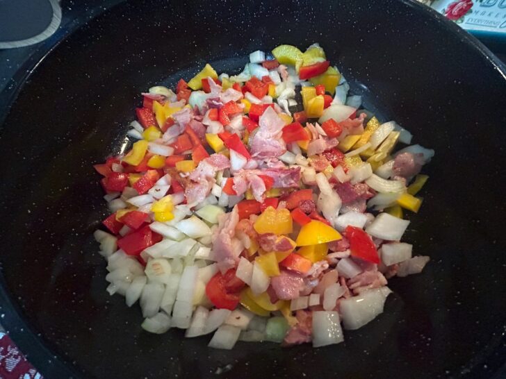 chopped vegetables in skillet with bacon