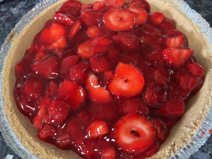 strawberry pie filling in graham cracker crust, ready to chill in the refrigerator