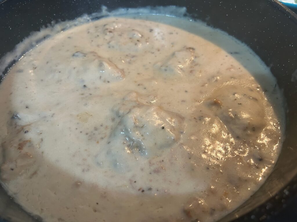 beef steaks in pan smothered in thickened gravy