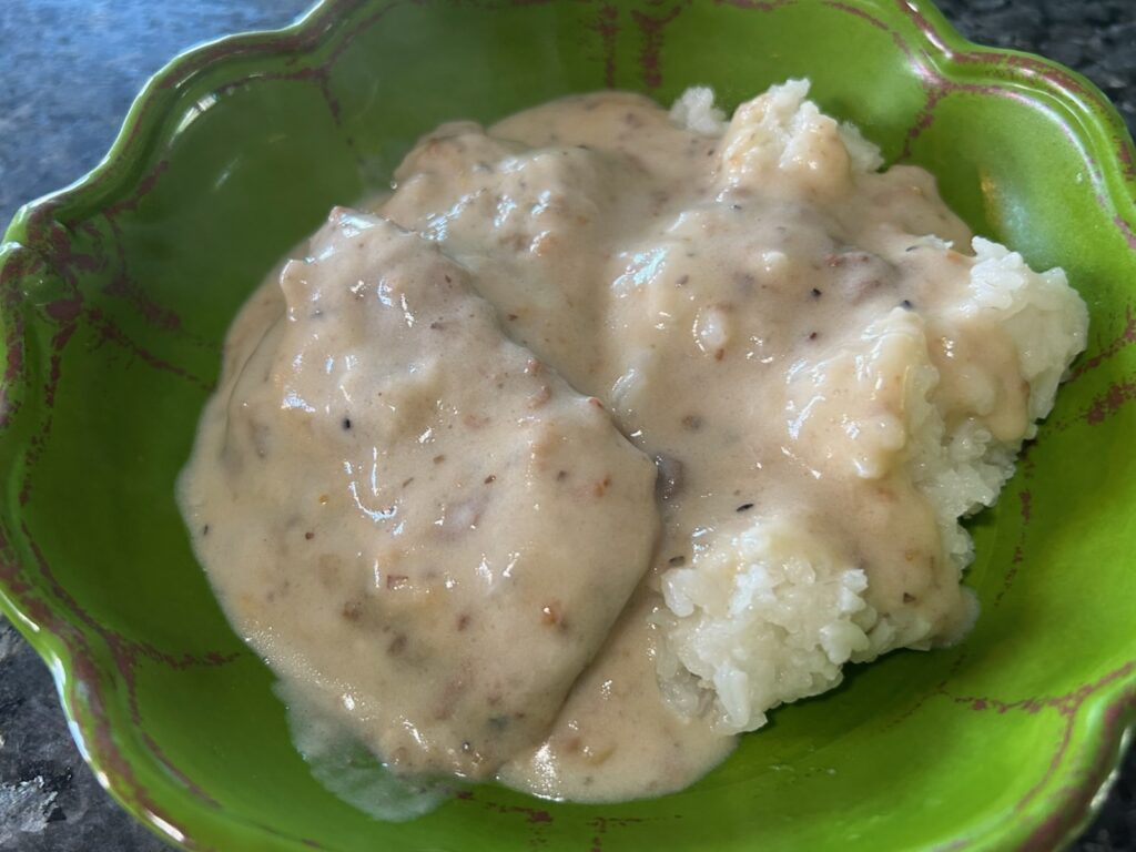 smothered round steak with mushroom gravy and rice in bowl