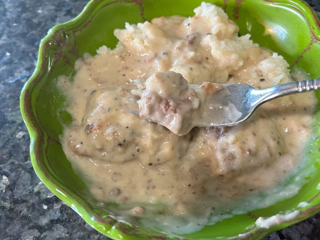 smothered round steak with mushroom gravy and rice in bowl