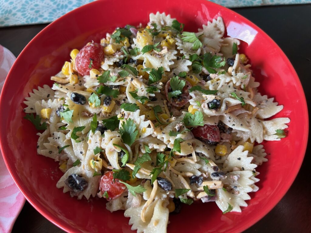 pasta salad in pretty bowl, garnished with cilantro