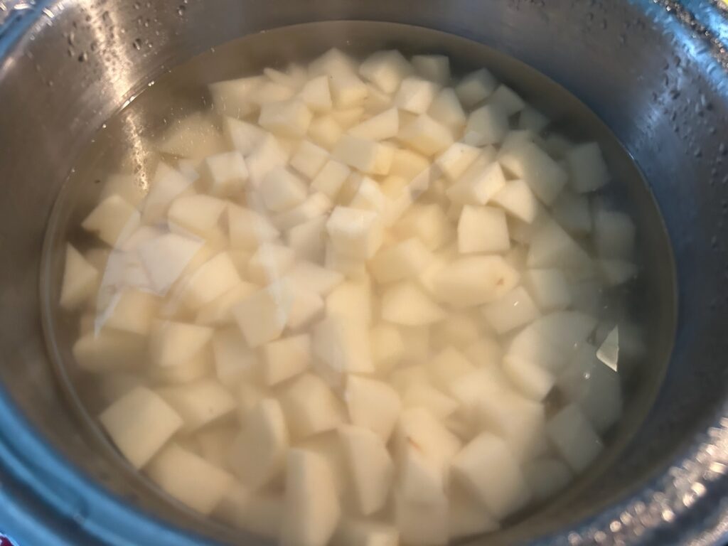 cubed potatoes in pan filled with water