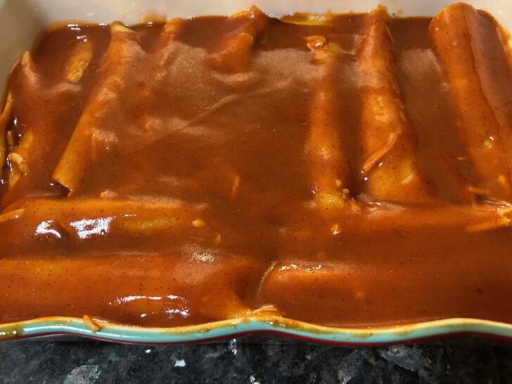 enchiladas in baking dish with sauce poured on top