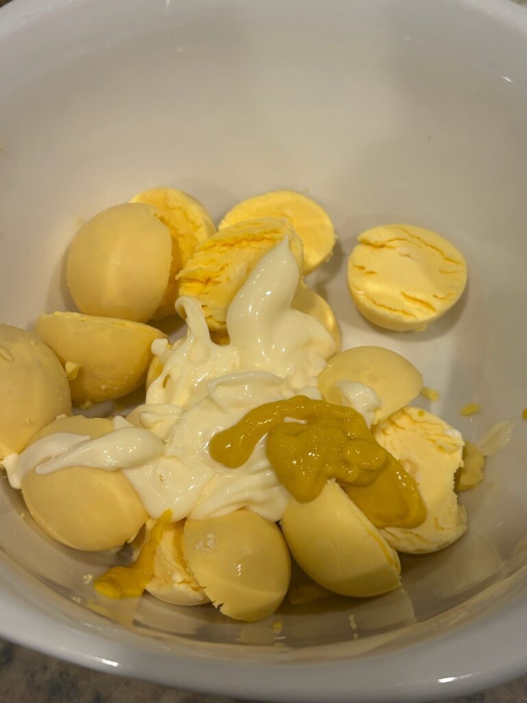 egg yolks in bowl with mayonnaise an mustard