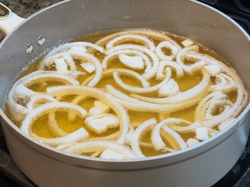 beer, broth, and onions in pan
