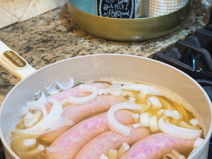 Texas Beer Brats simmering in beer and onion