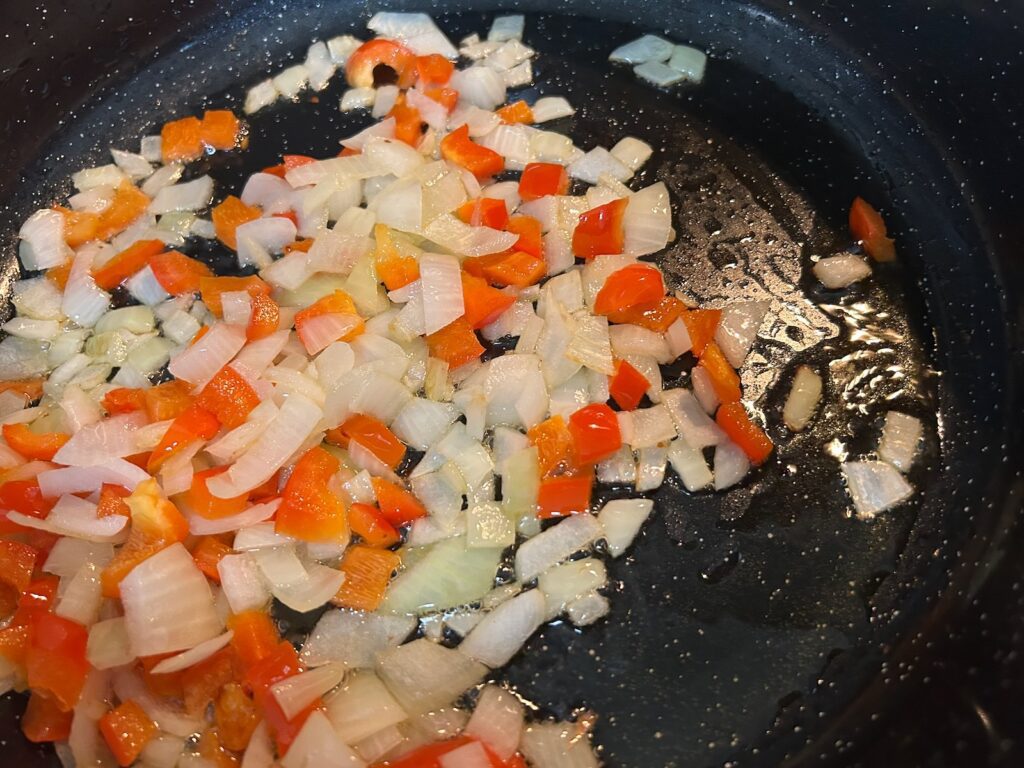 diced onion and red pepper sauteeing in pan