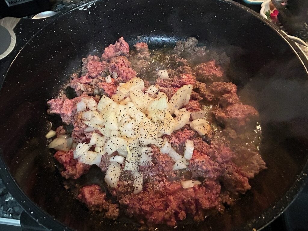 ground beef with onion in skillet