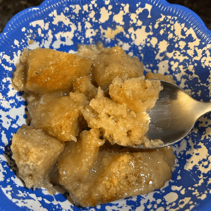 Old-Fashioned Bread Pudding with Brown Sugar Vanilla Sauce in bowl with spoon
