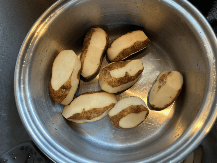 russet potatoes partially peeled in pan