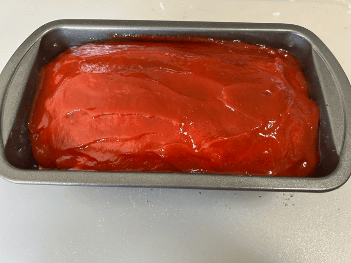 ketchup added to meatloaf in pan