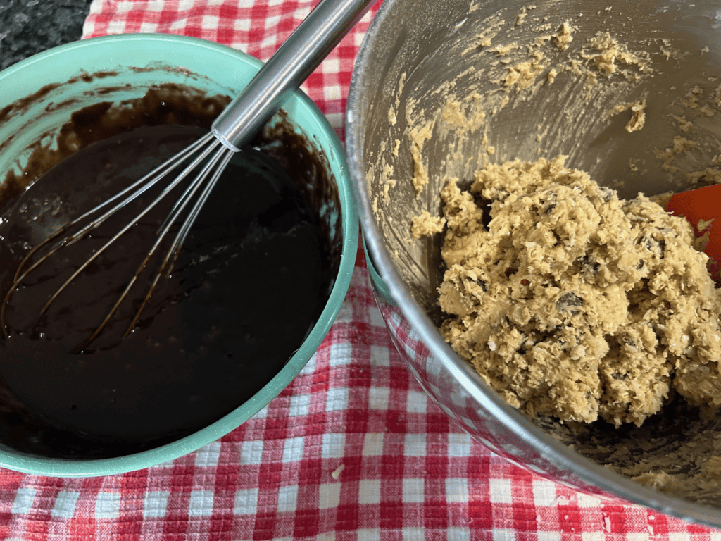 brownie batter in bowl next to cowboy cookie dough