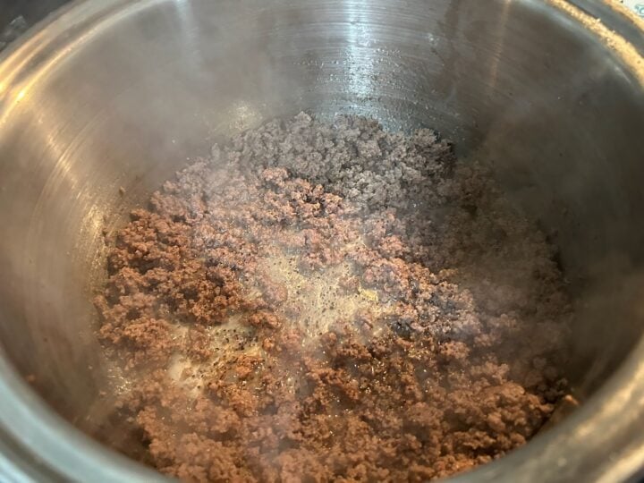 ground beef simmering in pan